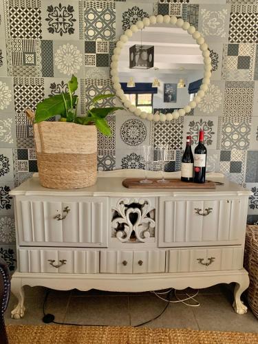a white dresser with a mirror and a plant on it at Belvidere Country Estate in Karkloof Nature Reserve