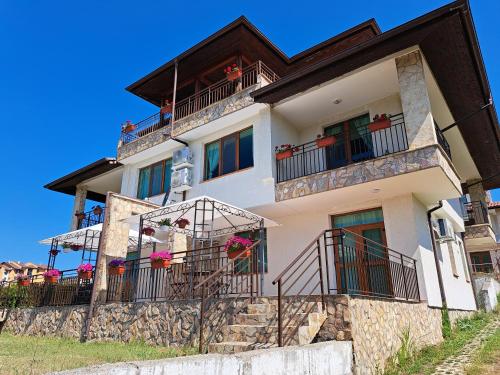 une grande maison blanche avec balcon sur une colline dans l'établissement Buongiorno! Premium, à Sveti Vlas