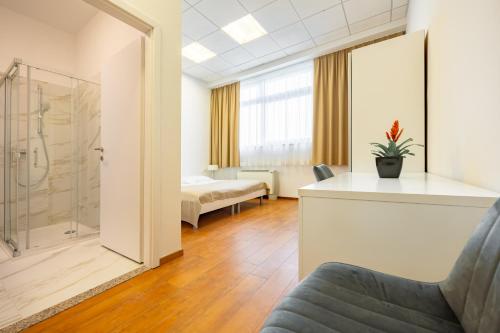 a hotel room with a shower and a bedroom at Garni Hotel Azul in Kranj