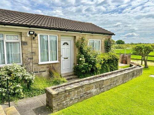 una casa con un muro di pietra di fronte di The Cottage a York