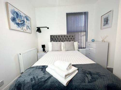 a white bedroom with a large bed with towels on it at Vicar Road in Liverpool