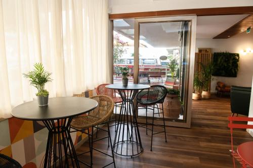 2 mesas y sillas en una habitación con ventana en Hotel Mirabella, en Riccione
