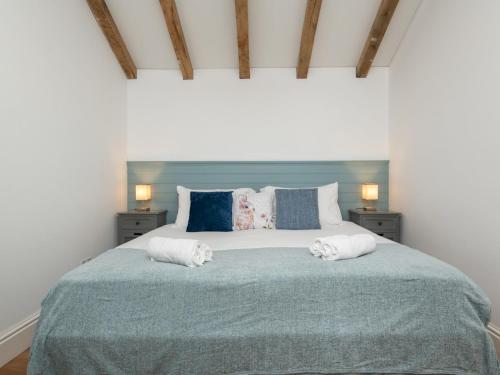 een slaapkamer met een groot bed en 2 handdoeken bij Pass the Keys Charming Garden cottage with parking in Bath