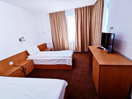 Habitación de hotel con 2 camas y TV en Hotel Muncel Băile Felix, en Băile Felix