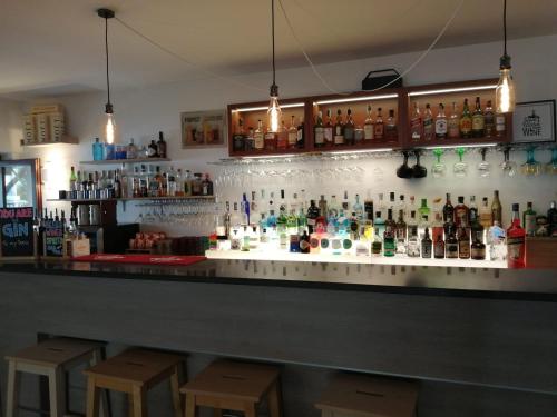 un bar avec beaucoup de bouteilles sur le mur dans l'établissement Malì Trevignano Piccolo Hotel, à Trevignano Romano