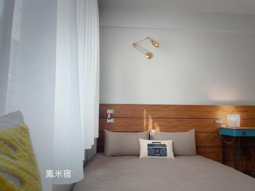 ein Schlafzimmer mit einem Bett mit einer Uhr drauf in der Unterkunft 鳳米宿Roomi house3 in Tainan