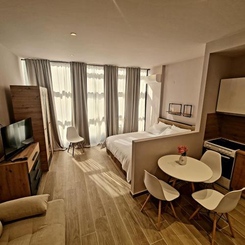 a hotel room with a bed and a table and chairs at Jo's downtown modern apartment. in Ioannina