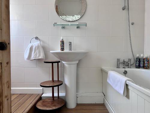 a white bathroom with a sink and a bath tub at Cosy Weavers Cottage - Heart of Frome in Frome