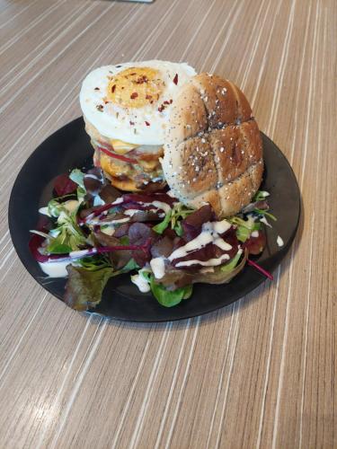 a sandwich with an egg and a salad on a plate at L'hacienda de Maria montchanin in Montchanin