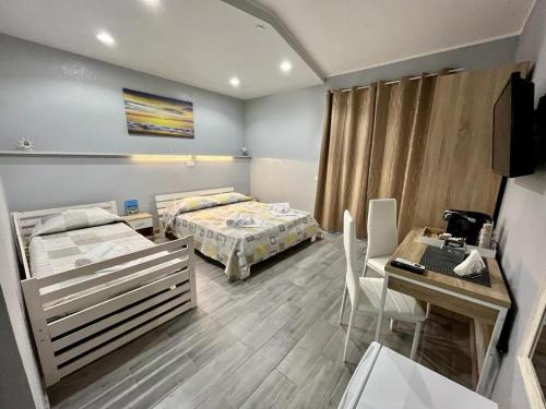 a room with two beds and a table and a desk at The Queen Tropea in Tropea