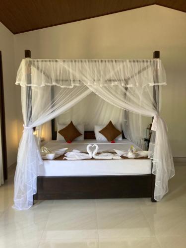 1 dormitorio con 1 cama con dosel en The View Hotel Sigiriya en Sigiriya