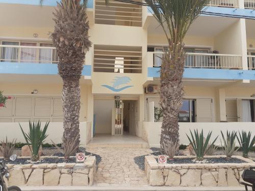 a building with palm trees in front of it at S4A Trilocale vista Mare in Sal Rei
