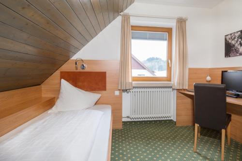 梅肯博伊倫的住宿－Hotel Jägerhaus，一间卧室配有一张床、一张桌子和一台电脑