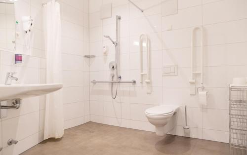 een badkamer met een douche, een toilet en een wastafel bij Hotel Jägerhaus in Meckenbeuren