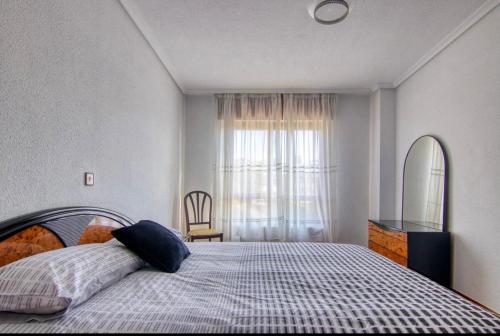 Pisos Sardinero في سانتاندير: غرفة نوم بسرير ونافذة كبيرة