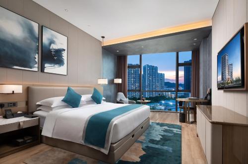 een slaapkamer met een groot bed en een groot raam bij Wyndham Garden Shenzhen Longhua in Shenzhen