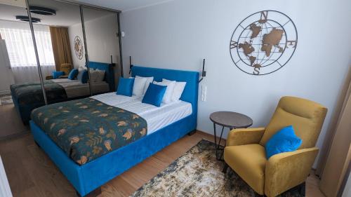 a bedroom with a blue bed and a chair at Eimrant Apartment at Vallikraavi in Tartu