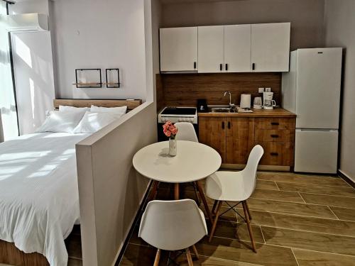 a bedroom with a bed and a table and a kitchen at Jo's downtown modern apartment. in Ioannina