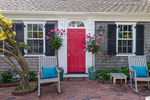 a red door on a house with two chairs at Martin House 157 in Provincetown
