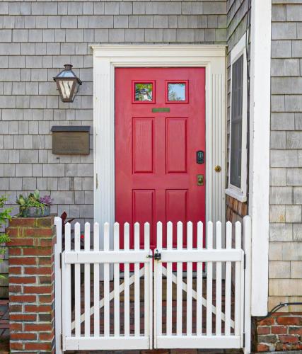 a red door on a house with a white fence at Martin House 157 in Provincetown