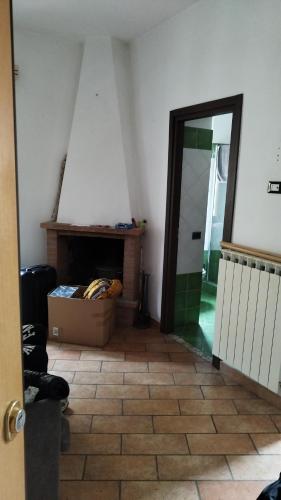 Habitación con chimenea y caja en el suelo en Home Monterotondo Ryder cup, en Monterotondo
