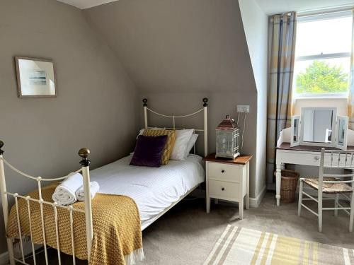a small bedroom with a bed and a window at Riverside Apartment in Uny Lelant