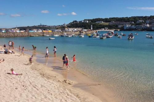 a group of people on a beach near the water at Riverside Apartment in Uny Lelant