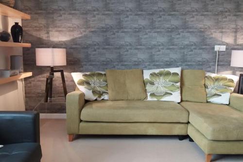 a living room with a couch and a brick wall at Riverside Apartment in Uny Lelant