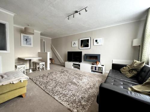 a living room with a couch and a tv at Riverside Apartment in Uny Lelant