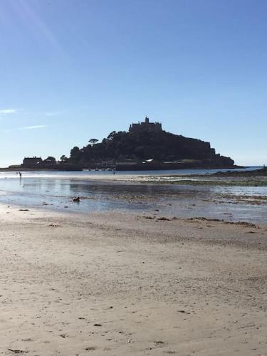 a beach with an island with a castle on it at Riverside Apartment in Uny Lelant