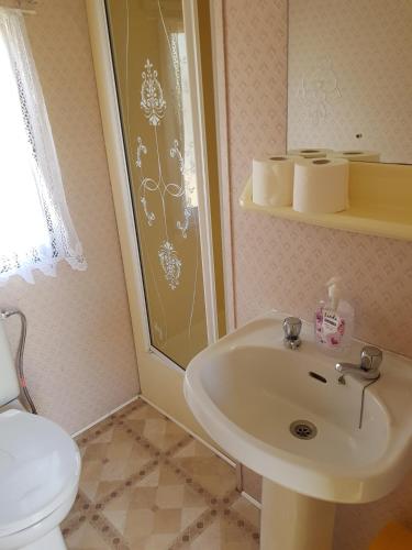a bathroom with a sink and a toilet at Rodzinne Domki Łeba in Łeba