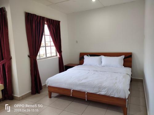 a bedroom with a bed and a window at TulipVilla Homestay in Kampong Parit