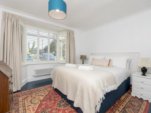 a white bedroom with a bed and a window at Pass the Keys Spacious family home with parking in Bath