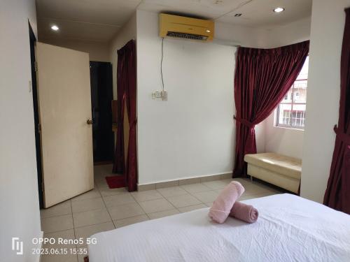 a bedroom with a white bed with a pink towel on it at TulipVilla Homestay in Kampong Parit