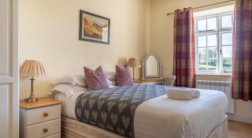 1 dormitorio con cama, espejo y ventana en Loweswater en Sawrey