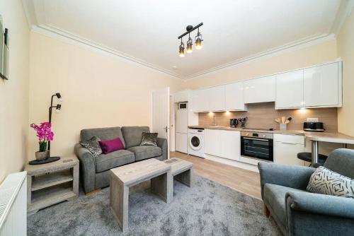 uma sala de estar com um sofá e uma mesa em Rosemount Residence - SJA Stays em Aberdeen