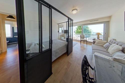 a living room with a bed and a couch at RÉF 119 LARMOR-PLAGE Appartement studio moderne in Larmor-Plage