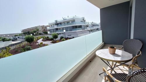 a balcony with a table and chairs and a building at Amplio y cómodo apartamento. in Granadilla de Abona