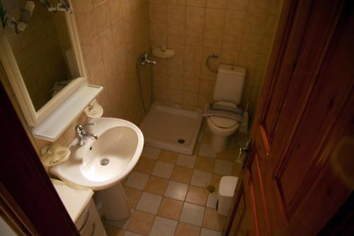 a small bathroom with a sink and a toilet at Avlonitis Rooms in Parga