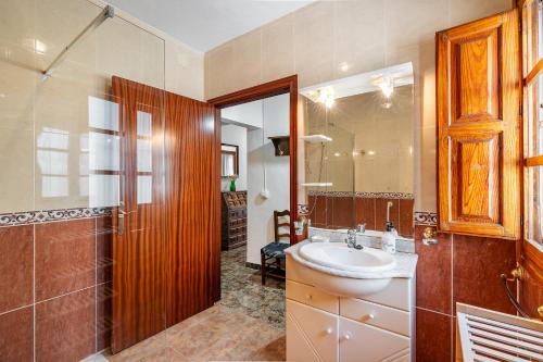 y baño con lavabo, ducha y espejo. en Casa Juan y Loli, en Nigüelas