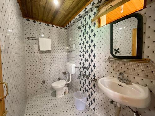 ein Bad mit einem Waschbecken und einem WC in der Unterkunft One Light Stays - Vashisht in Vashisht