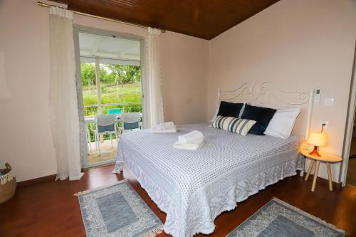 a bedroom with a white bed and a window at Summer House in Corfu Town in Mantoúkion