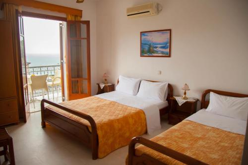 a hotel room with two beds and a balcony at Avlonitis Rooms in Parga