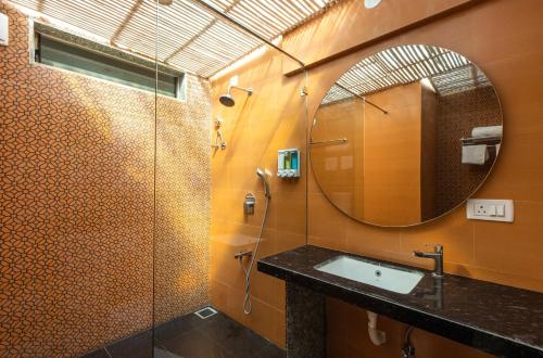 a bathroom with a shower and a sink and a mirror at Oceanature Alibaug in Alibaug