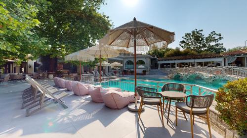 a patio with a table and chairs next to a pool at Acrotel Athena Pallas in Elia