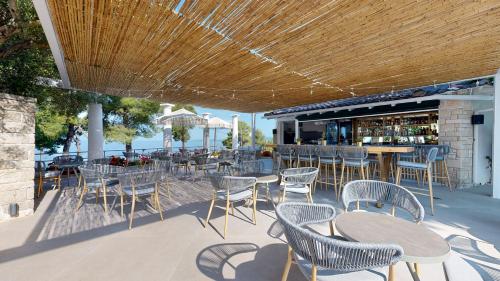 a patio with tables and chairs and a bar at Acrotel Athena Pallas in Elia