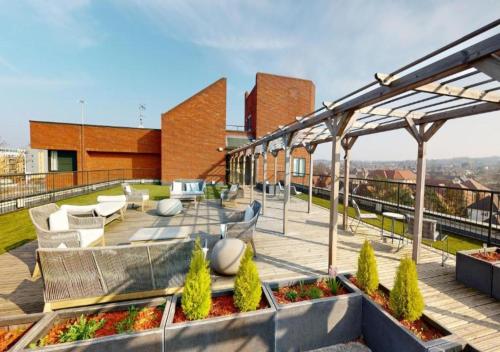 a rooftop patio with chairs and tables on a building at Luxury 1-Bed Town Centre Platform South Stevenage in Stevenage