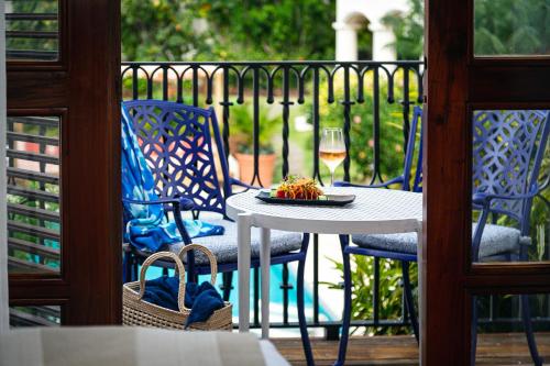 a table with a plate of food and a glass of wine at Cap Maison Resort & Spa in Cap Estate