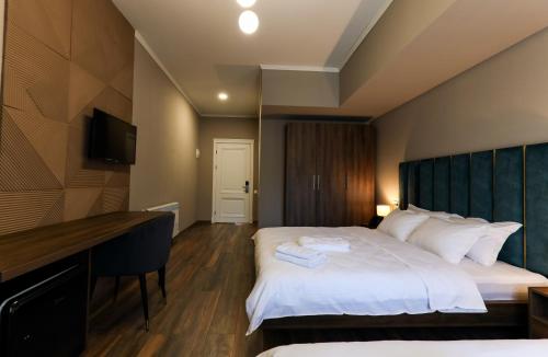 a hotel room with a bed and a desk at Gelati Residence in Kutaisi