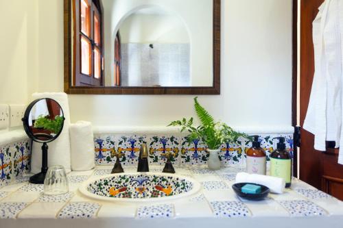 a bathroom counter with a sink and a mirror at Cap Maison Resort & Spa in Cap Estate